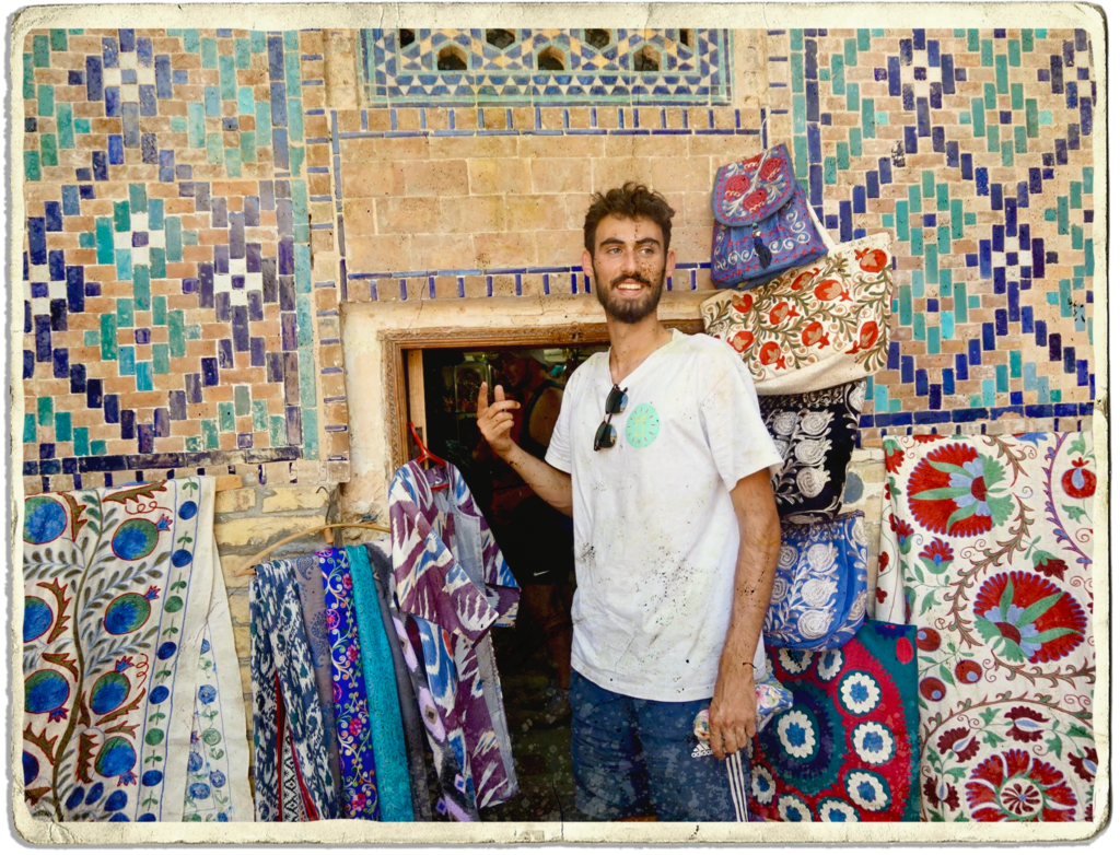 Edouard Paquet, founder and creative director at Next Stop Adventure is standing in front of the small door of a colourful shop in Samarkand, Uzbekistan