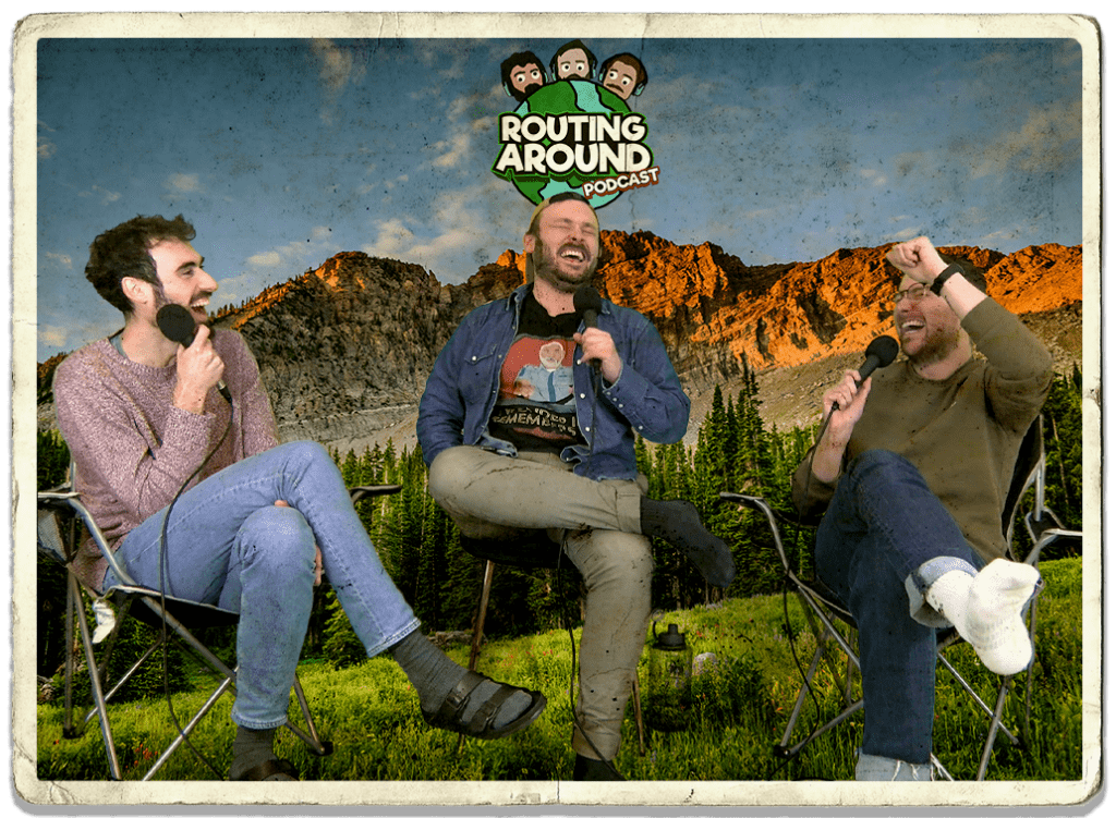 Routing Around podcast hosts Tom, Kevin and Edouard, founder of travel social media content agency Next Stop Adventures, sitting on camping chairs in front of a backdrop of mountains while recording an episode of the podcast. Included on the picture is the Routing Around podcast logo.